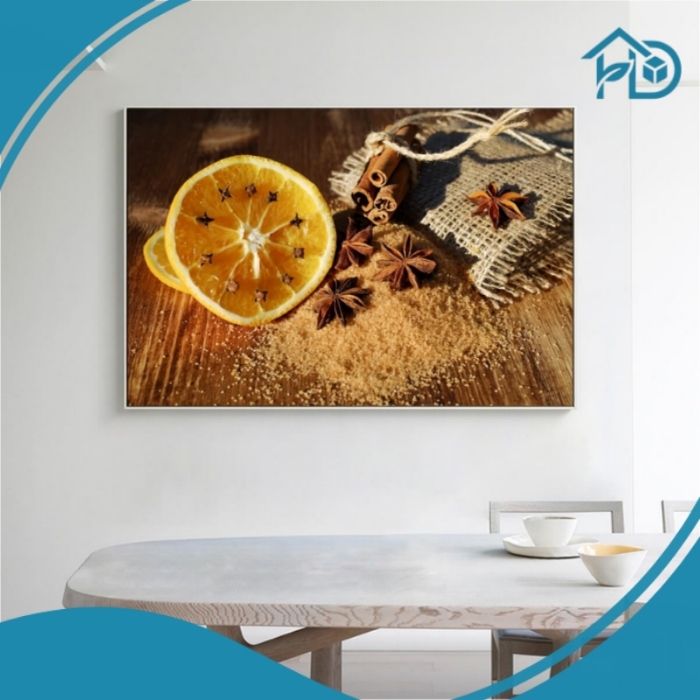 Tranh treo tường phòng ăn trái cam gia vị canvas hiện đại với hình ảnh cam, quế và hoa hồi tạo điểm nhấn ấm cúng cho không gian bếp.